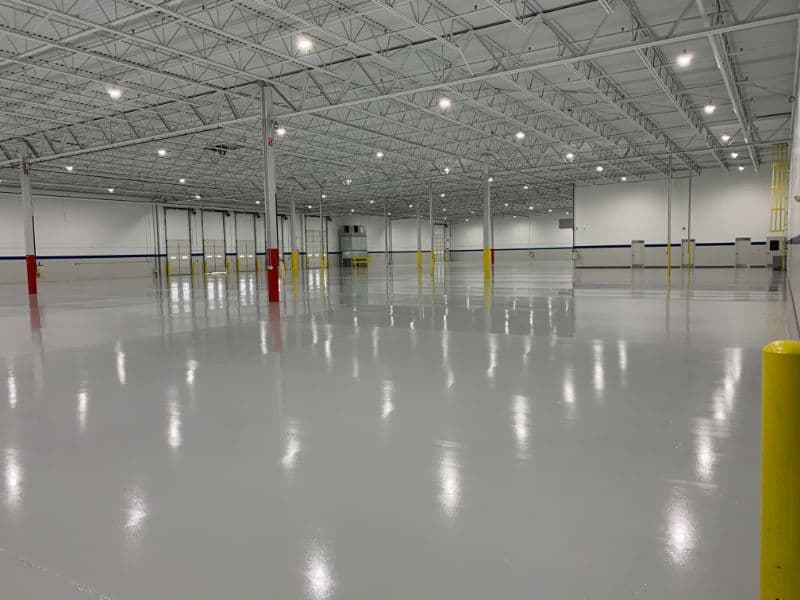 Spacious, freshly painted warehouse interior with high ceilings and bright lighting.