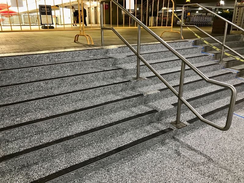 Sturdy outdoor steps with textured surface and handrails for accessibility.