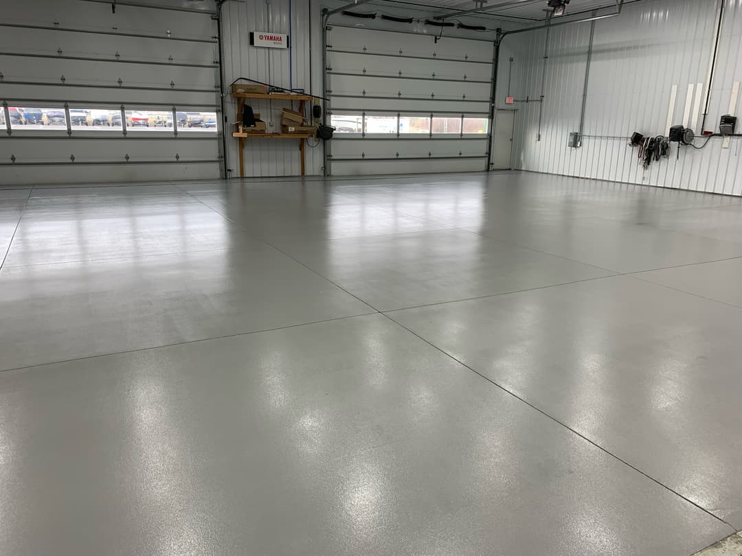 Spacious industrial garage with polished concrete floor and large roll-up doors.