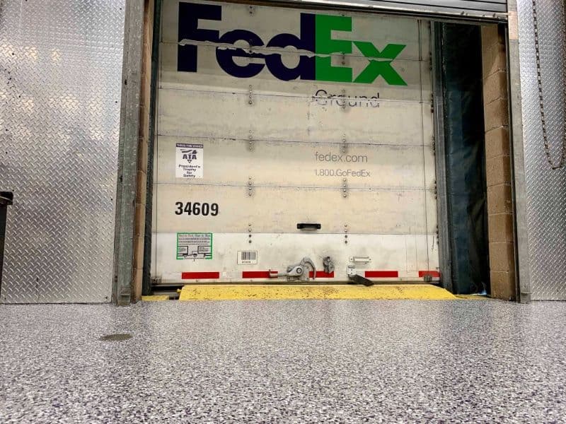 FedEx truck loading dock with visible company branding and polished concrete floor.