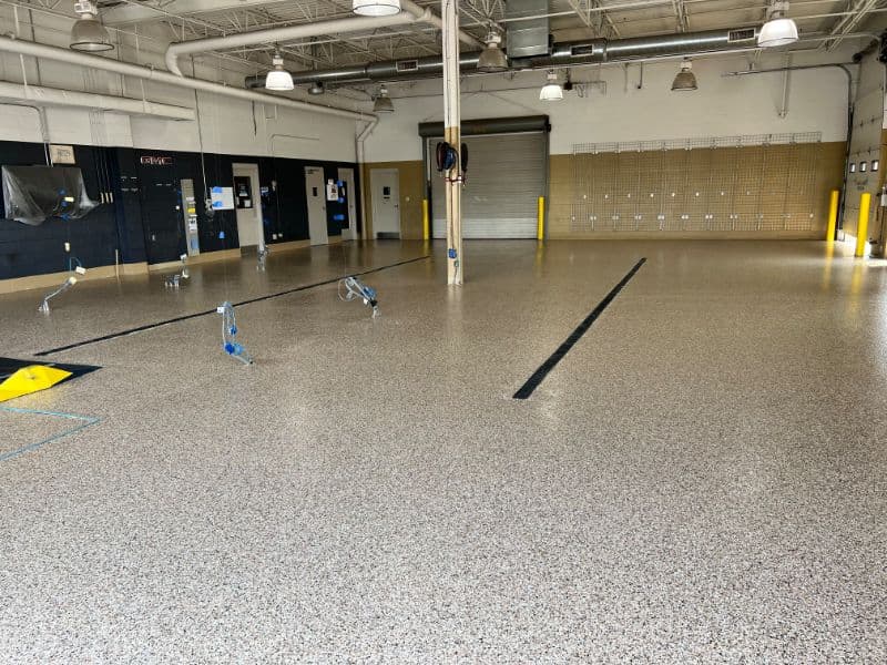 Spacious industrial floor with epoxy coating and safety features, ideal for workshops.