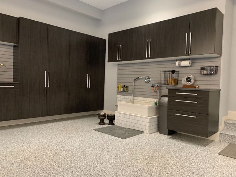 Modern garage interior with dark cabinetry, utility sink, and innovative storage solutions.