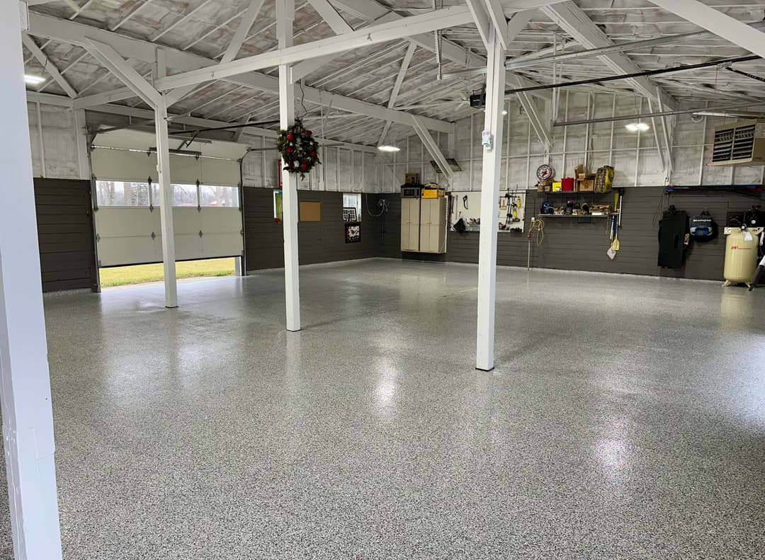 Spacious garage interior with polished flooring, tall ceilings, and organized storage.