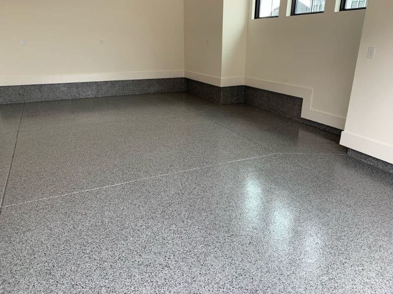 Polished gray epoxy floor in a spacious, well-lit room with corner details.