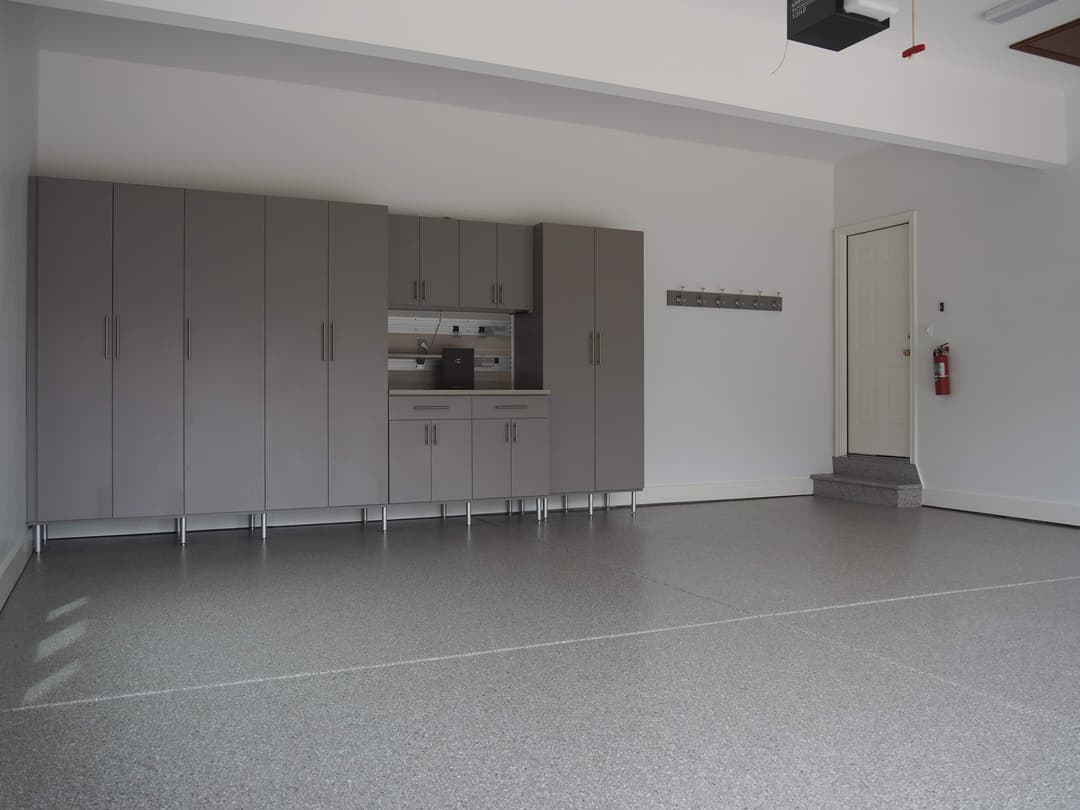 Modern garage with gray cabinets, polished floor, and organized storage space.
