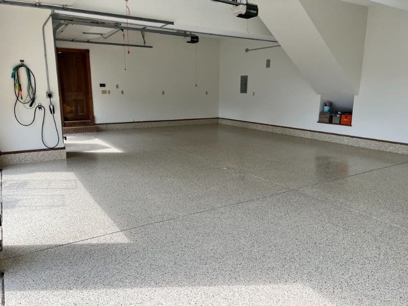 Spacious, clean garage with polished concrete floor and organized storage area.