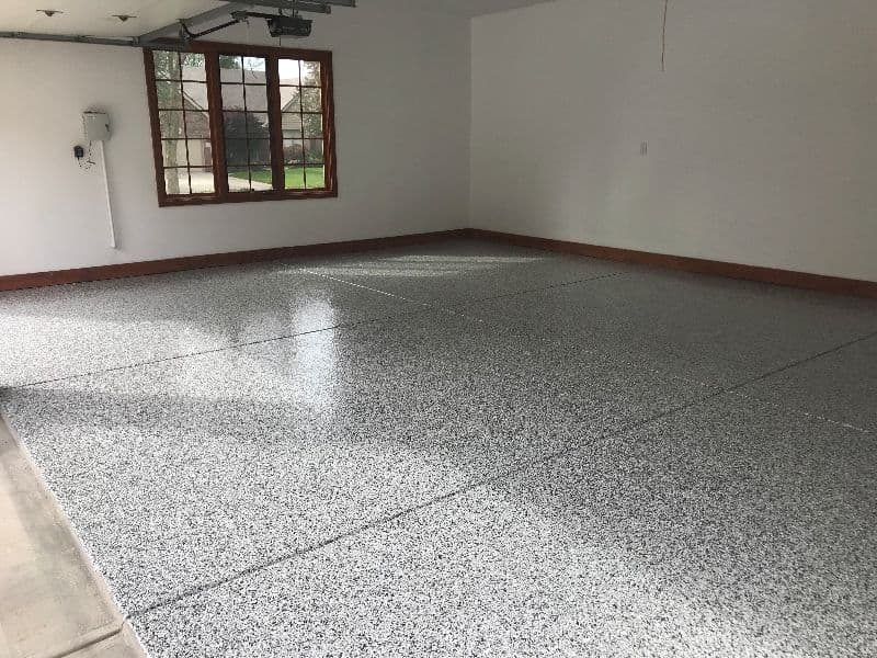 Clean, spacious garage with a polished granite-like epoxy floor and large window.
