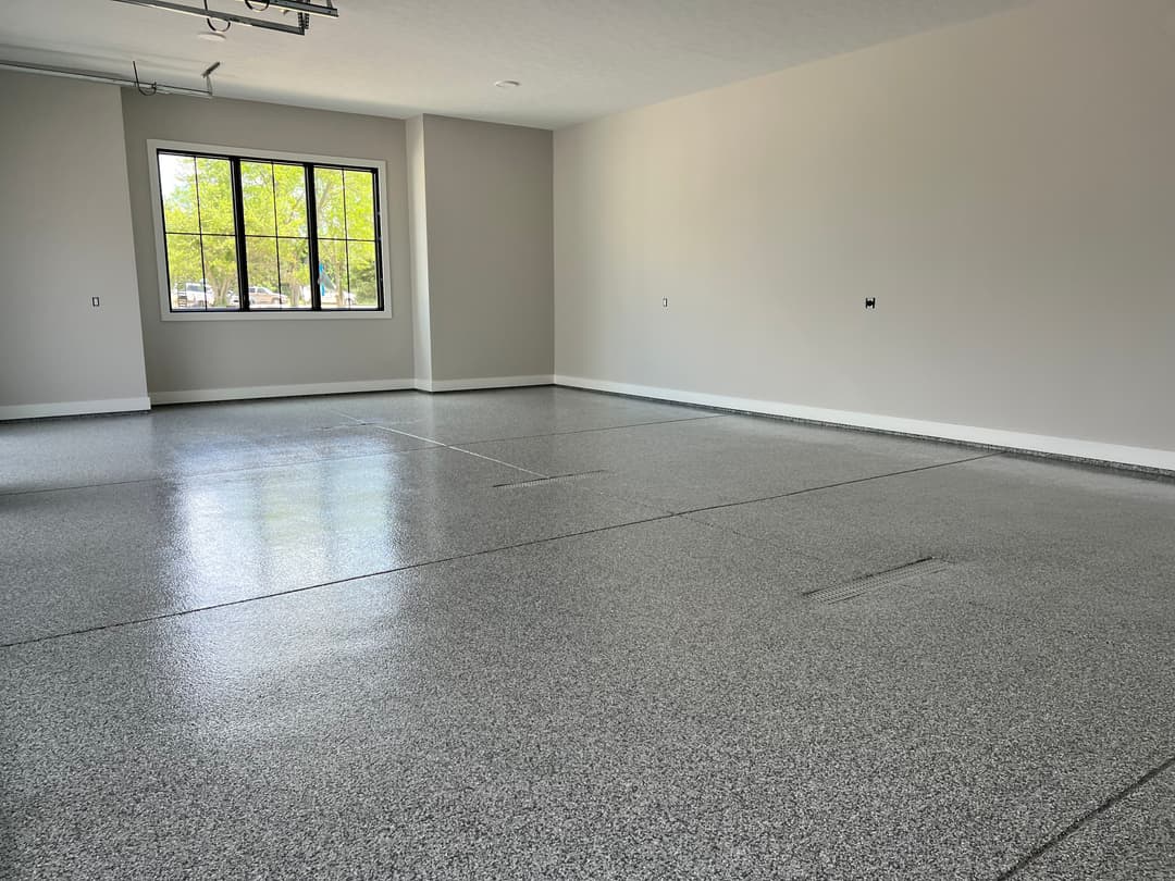 Spacious, bright garage with polished epoxy floor and large window.