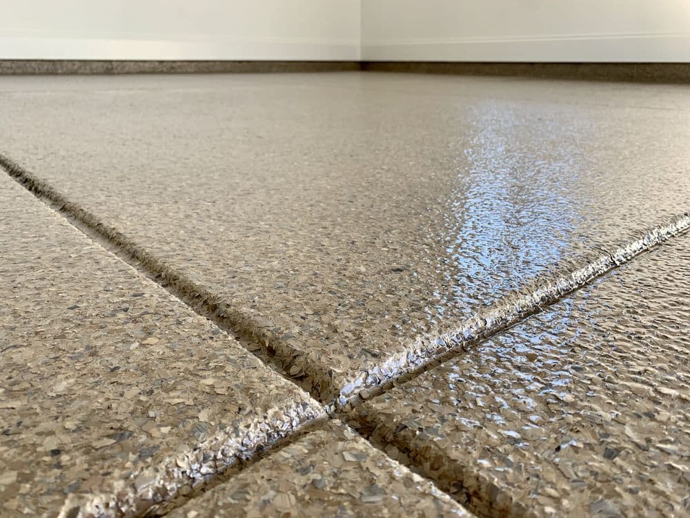 Glossy epoxy floor with textured finish and visible grout lines in a spacious interior setting.