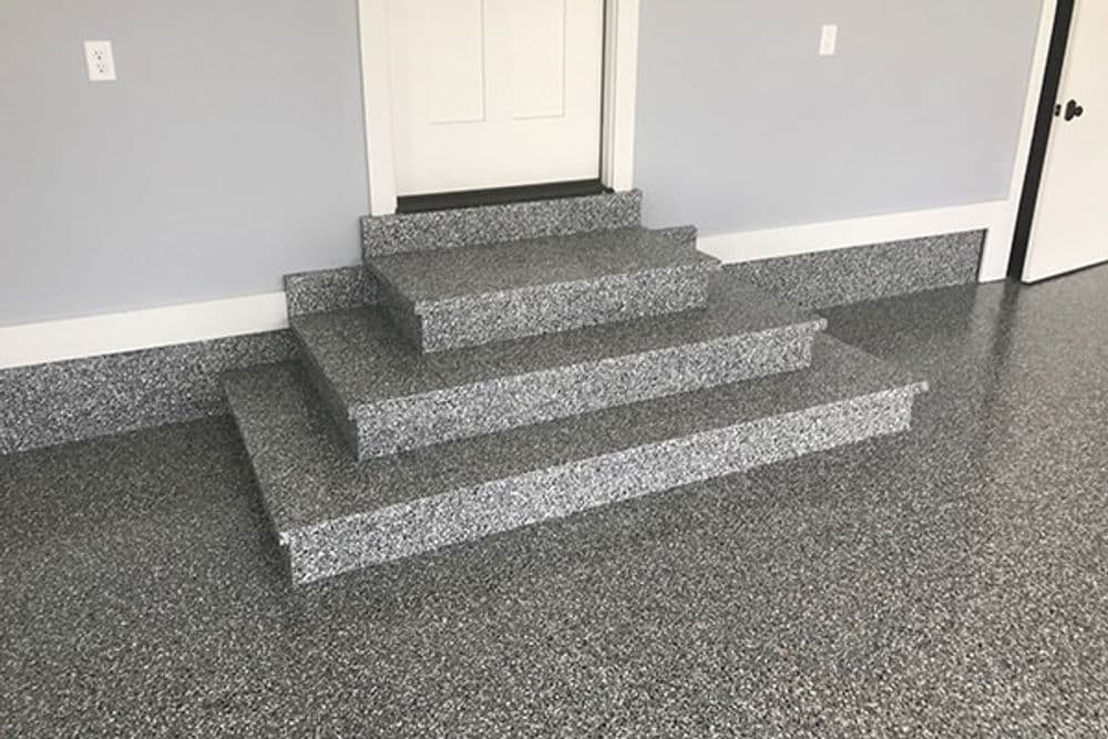 Decorative epoxy flooring on steps and landing in a modern garage interior.