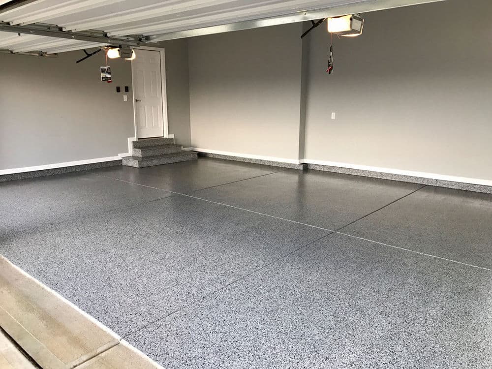 Modern garage interior with smooth gray epoxy flooring and white walls. Clean and spacious design.