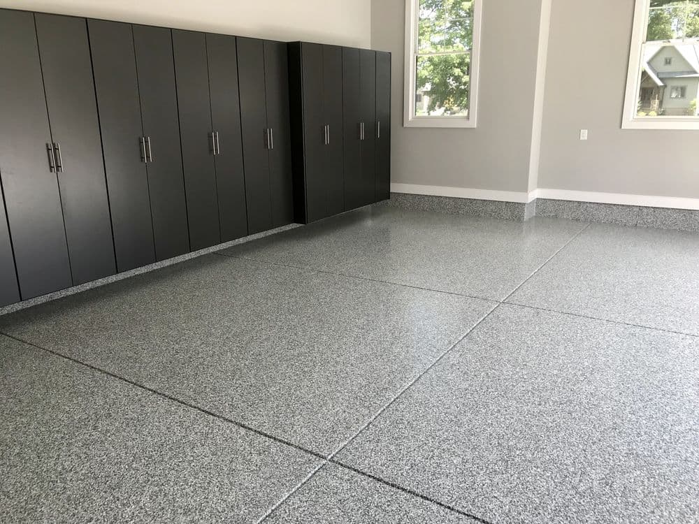 Modern garage with polished epoxy floor and sleek black storage cabinets.
