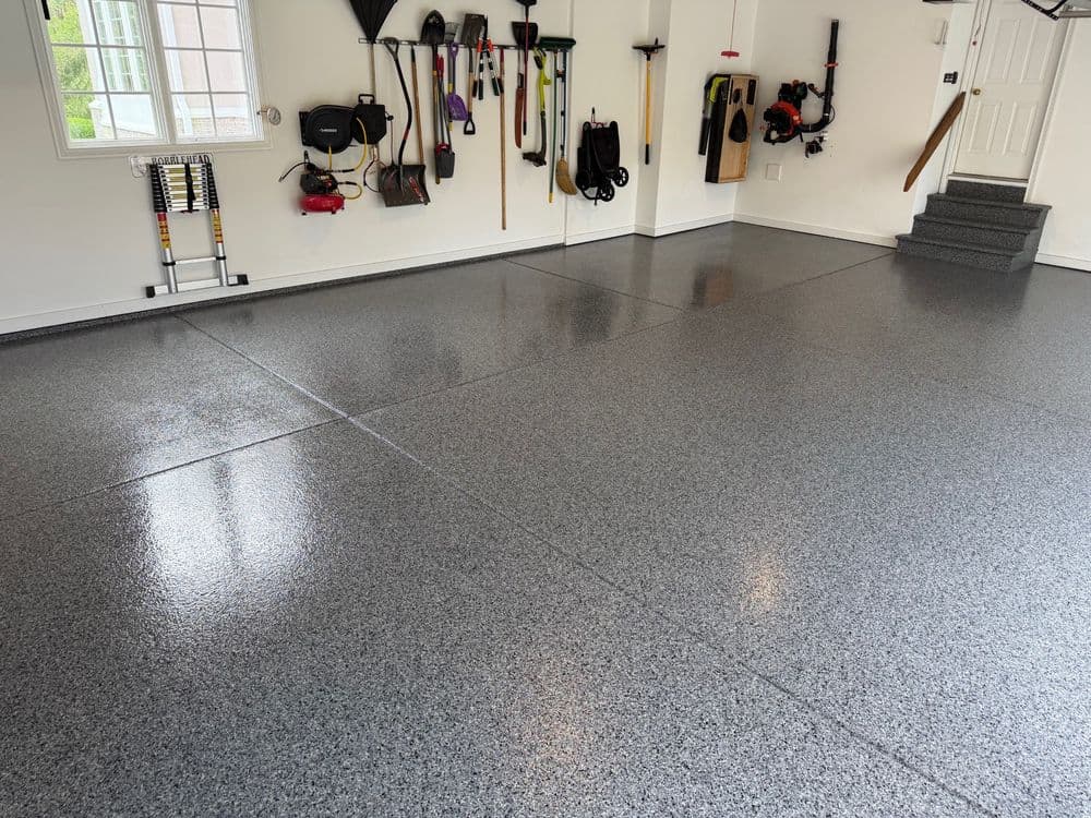Clean, polished gray garage floor with organized tools and equipment on walls.